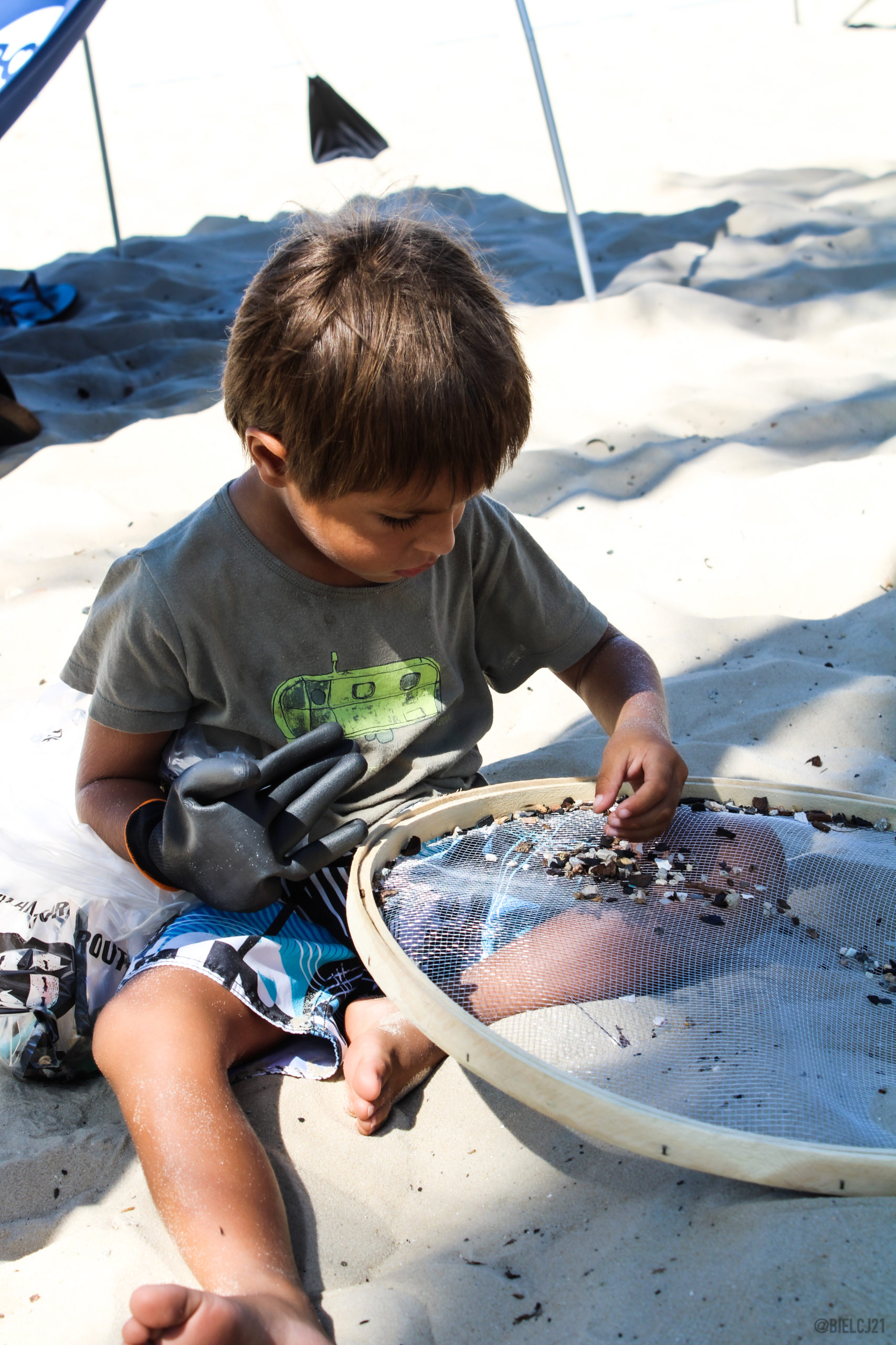 criança separando bituca de cigarro na ação de limpeza na praia do Leme - ROUTE Brasil